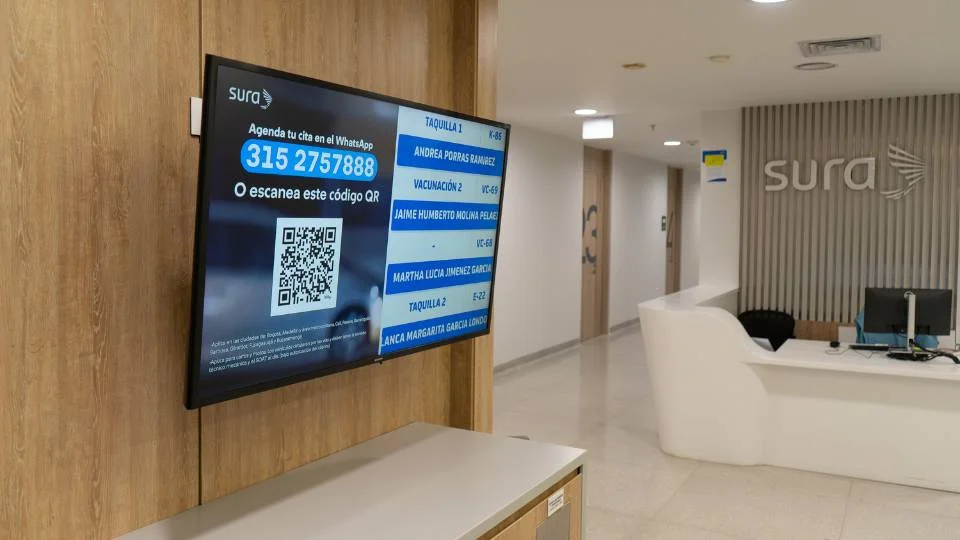 Reception screen showing a large QR code for remote appointment scheduling via WhatsApp
